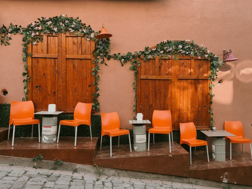 Warm, modern restaurant dining room with soft lighting, wooden tables set for dinner, and a relaxed, inviting atmosphere
