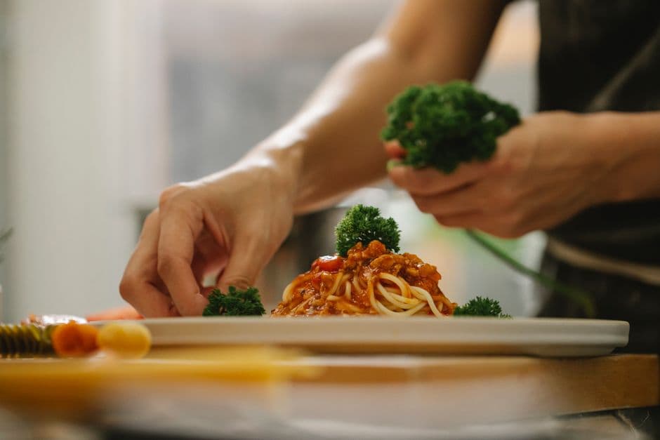 The warm, modern dining room at Savora — wooden tables, soft lighting, and a mix of couples and small groups settled in for a meal, the room full but unhurried